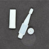 White plastic tumbler flipper tool with cap and base on dark surface