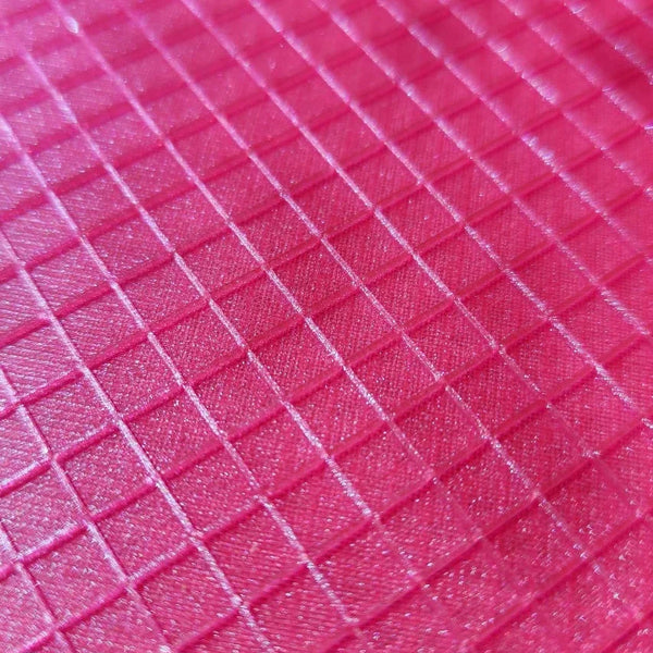 Pink textured crafting mat with grid pattern for rhinestone tumbler projects