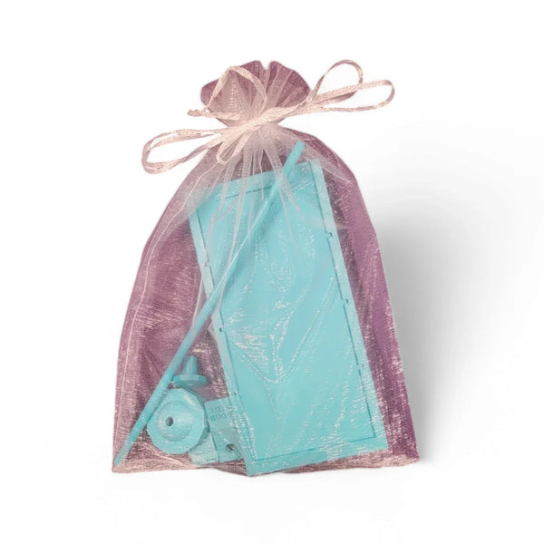 Turquoise flatback flipper tool in purple organza bag, perfect for rhinestone tumbler crafting