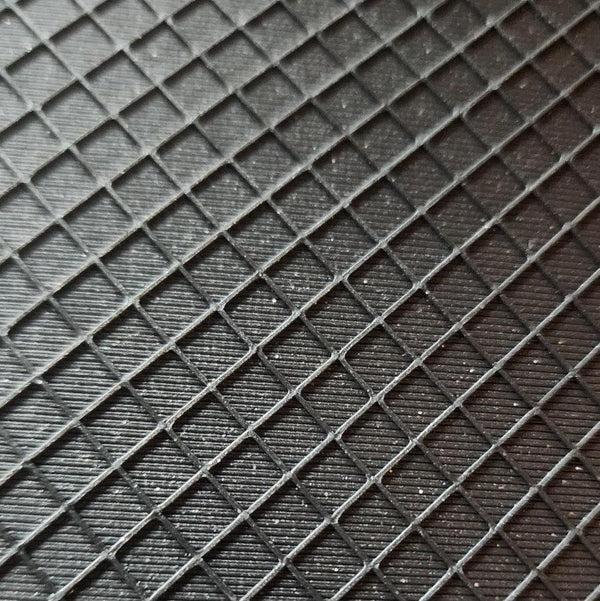 Close-up of a sparkly black rhinestone tray from the tumbler universe. textured surface with a repeating diamond grid pattern.