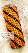 Orange and black rhinestone tumbler with striped bling design on fluffy white background