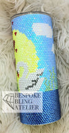 Rhinestone tumbler with snowman design, blue sky, and yellow sun on fluffy white background
