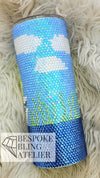 Rhinestone tumbler with blue, white, and green design on fluffy background