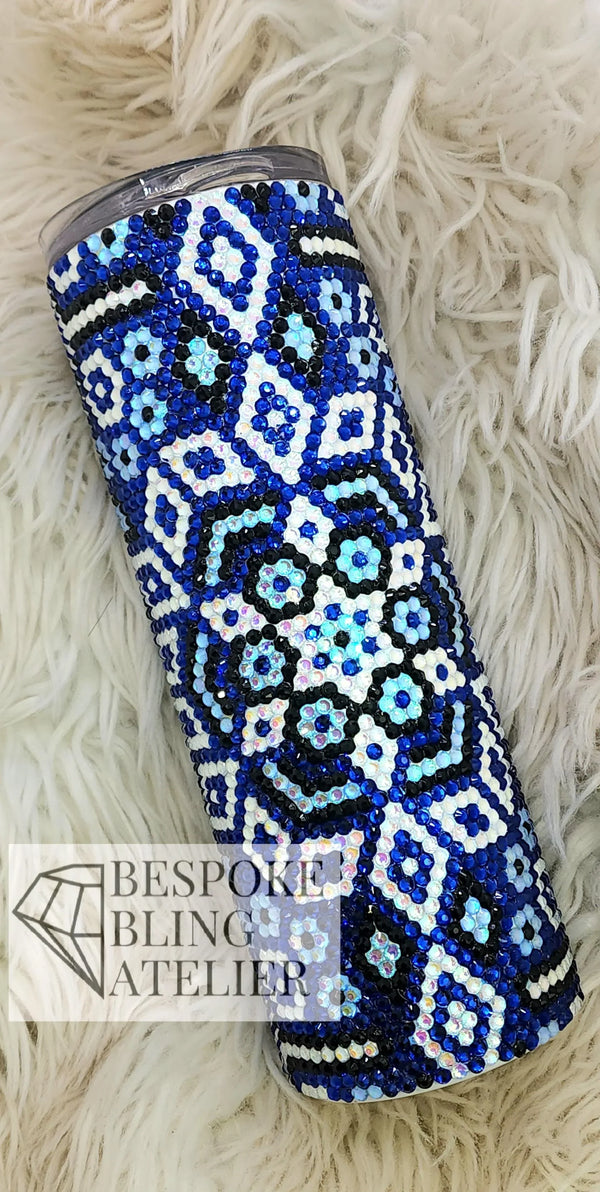 Blue and white rhinestone tumbler with intricate floral patterns on a fluffy background