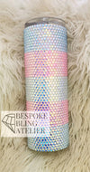 Rhinestone-embellished tumbler with pastel stripes on fluffy background, perfect for bling crafting.