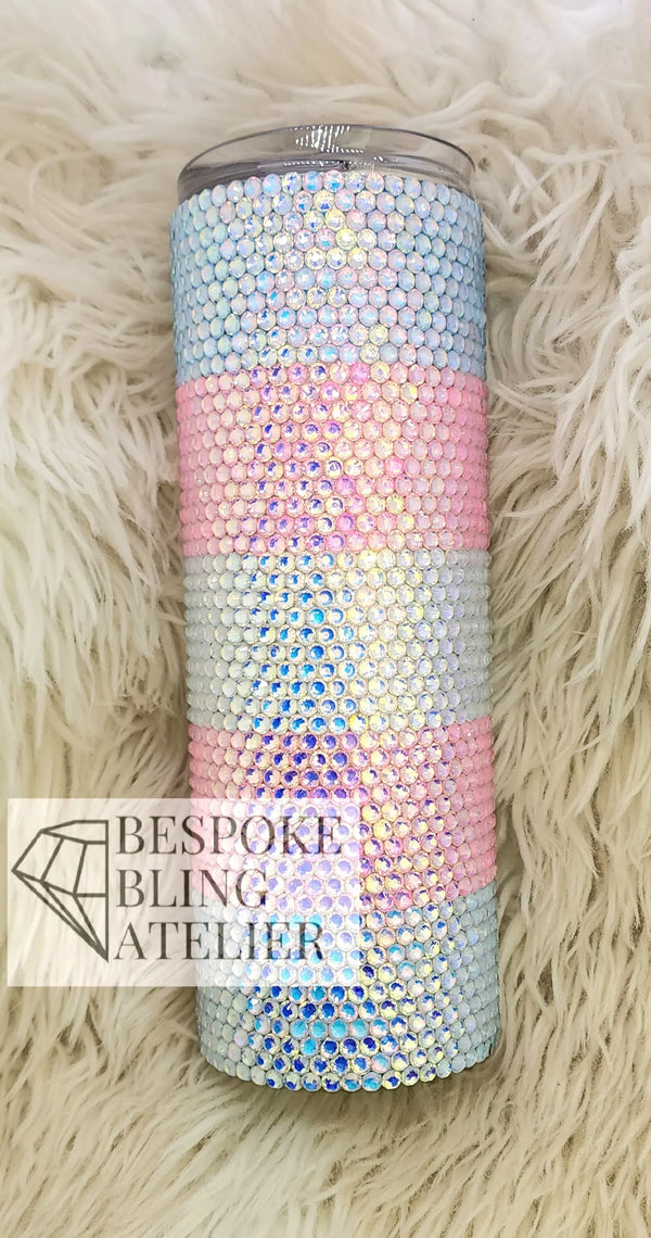 Rhinestone-embellished tumbler with pastel stripes on fluffy background, perfect for bling crafting.