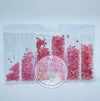 Pink rhinestones in clear organizer bag for tumbler crafting, assorted sizes and shades